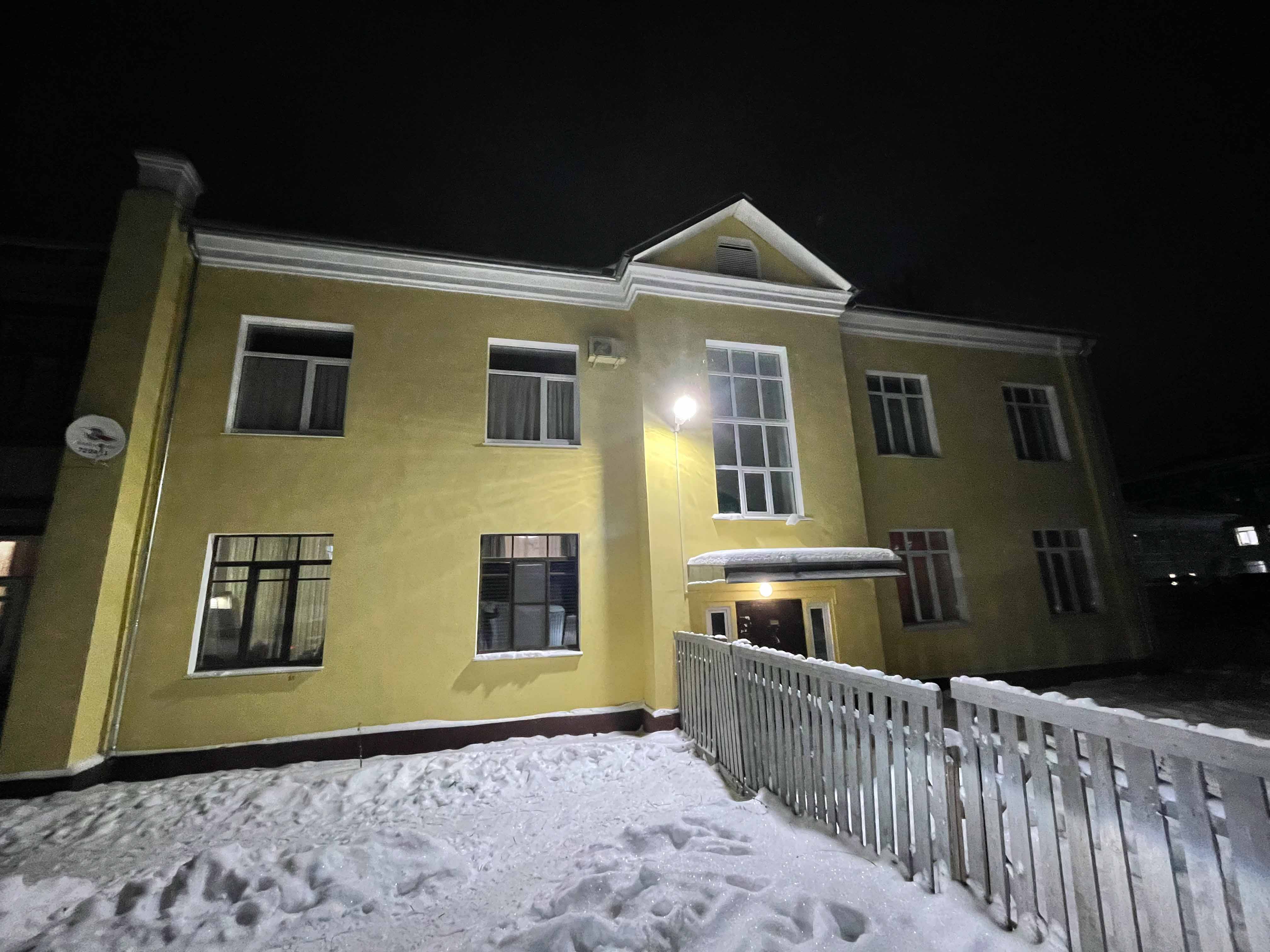 Каменный дом с апартаментами VologDom зимним вечером